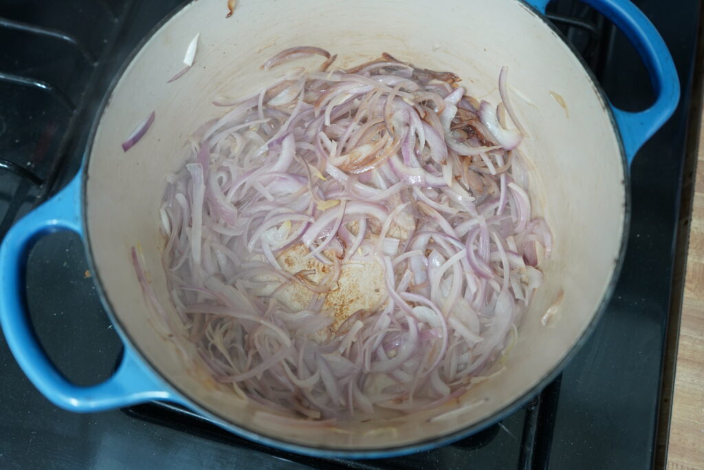 softened red onion in a pot