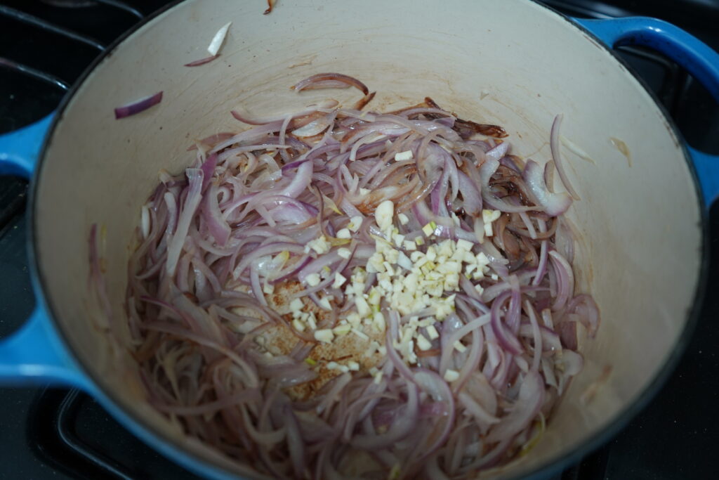 minced garlic in a Dutch oven of caramelized onion