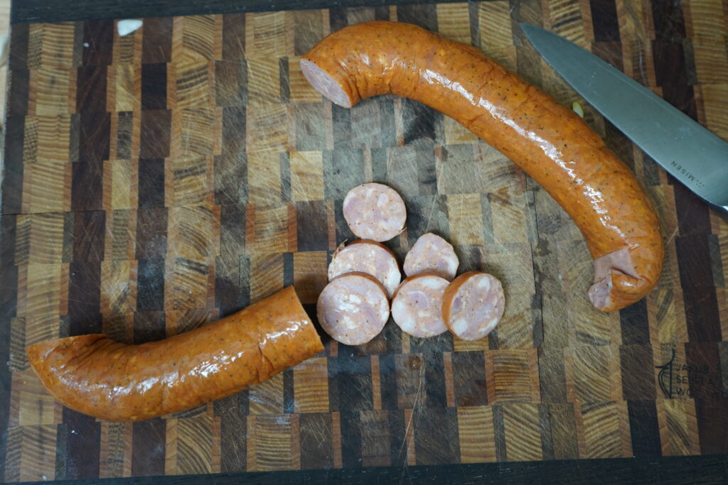 smoked sausage being cut up