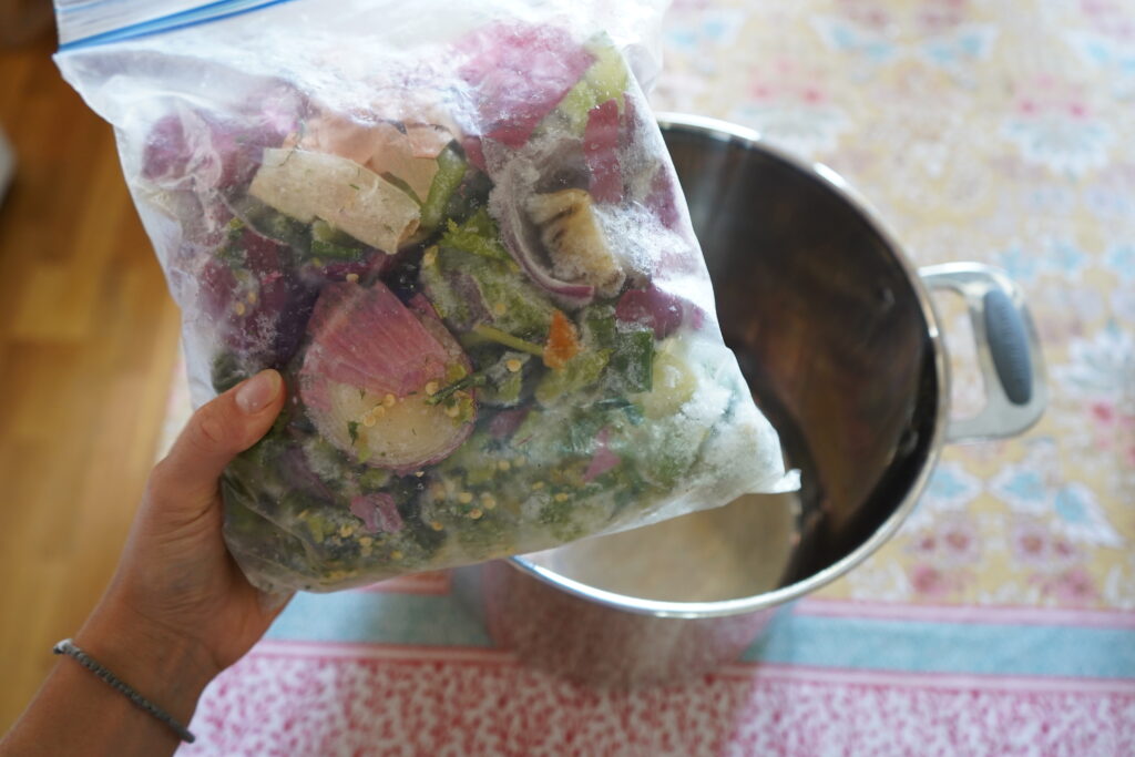 a bag of frozen vegetables over a stainless steel pot