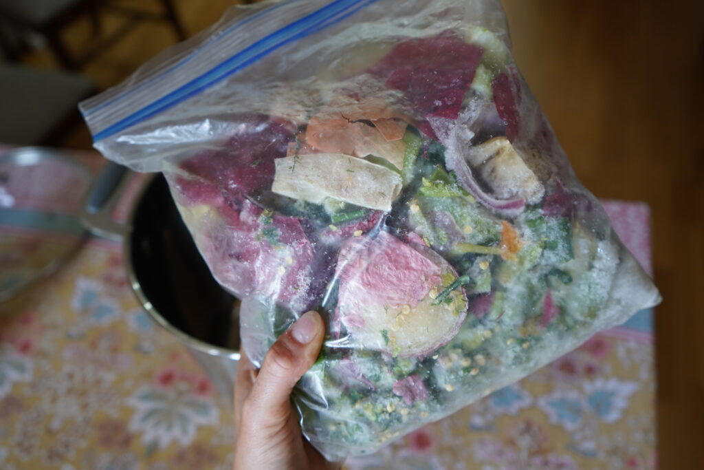 a large zip lock filled up with vegetable scraps