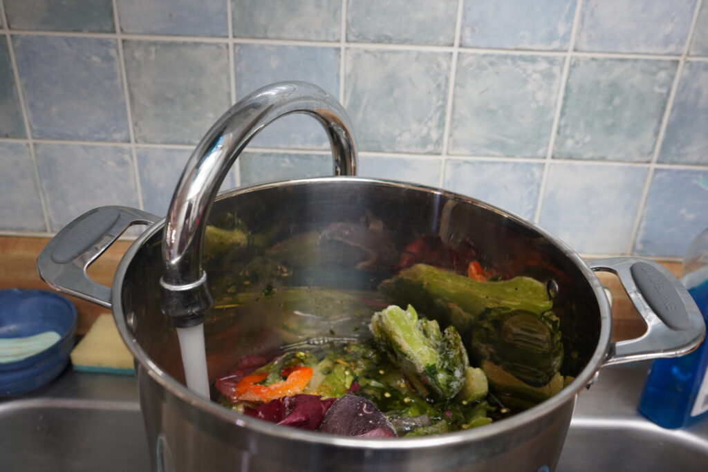 water fillinf up apot of vegetables