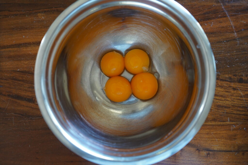 four egg yolks in a small bowl