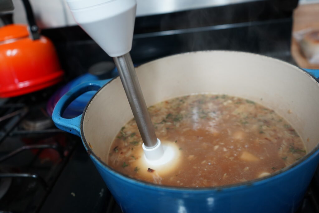 an immersion blender in a pot blending