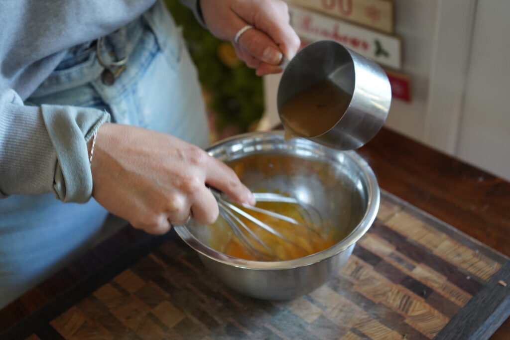 a silver bowl with liquid and a whisky moving quickly as liquid is poured in