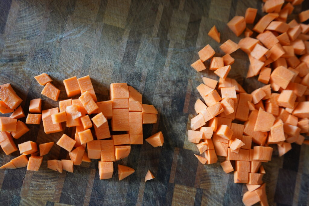 a sweet potato cubed on a cutting bored