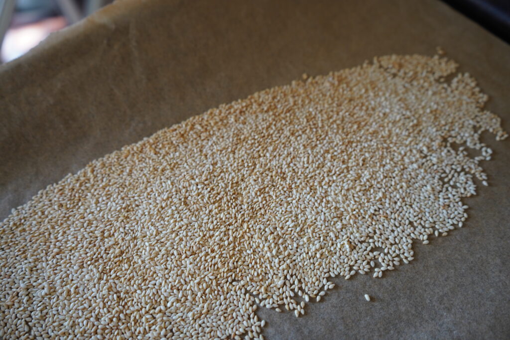 a baking tray with golden brown seseme seeds