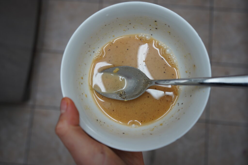 a white bowl with dressing inside