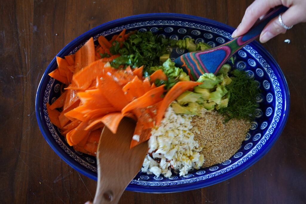 two wooden spoons mixing up a salad