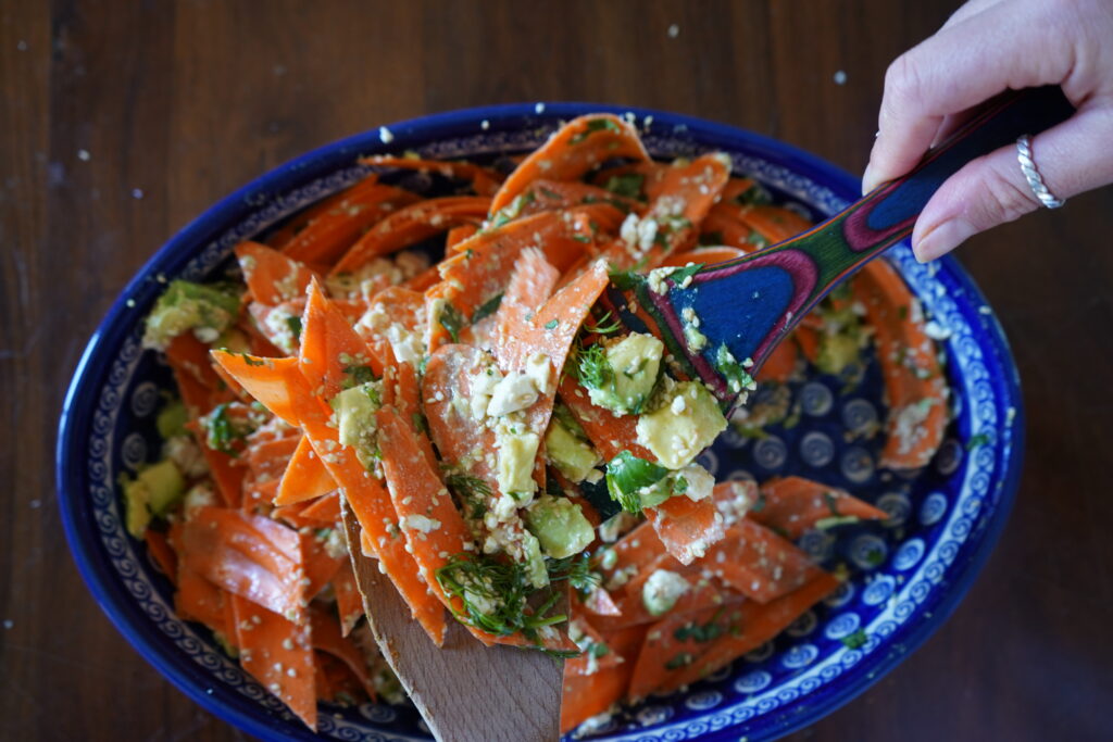 a feta and carrot salad being mixed