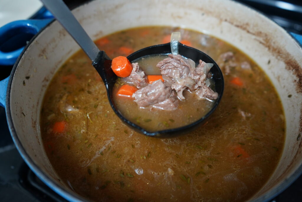 a spoon, spooning out beef and carrot stew