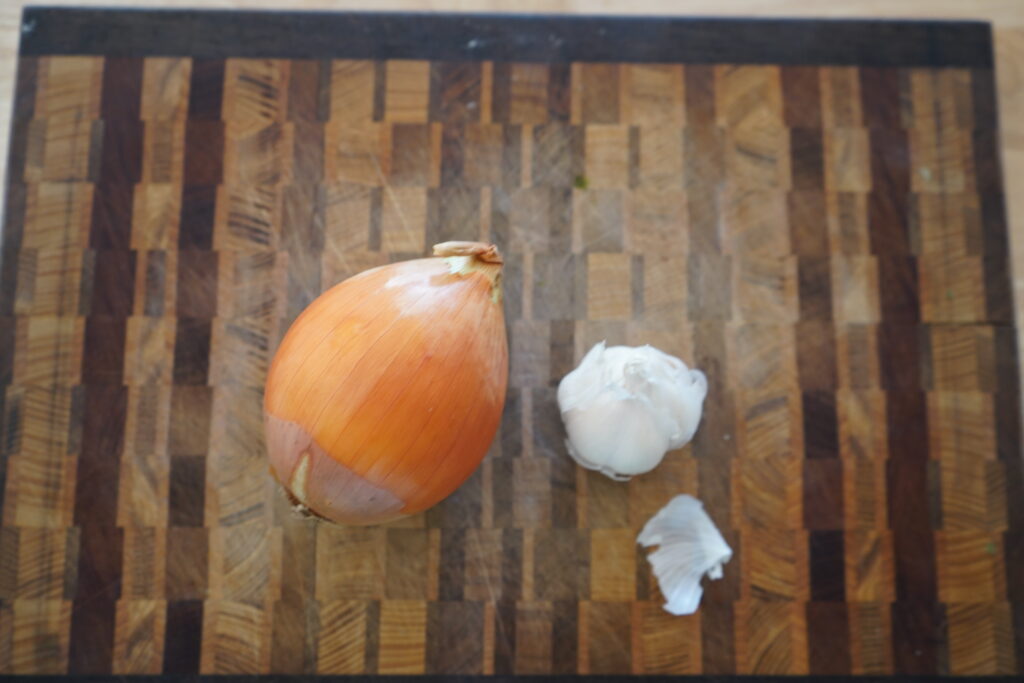 an onion and garlic on a cutting board