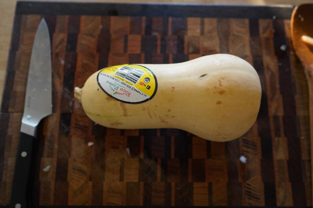 a whole organic butternut squash on a cutting board