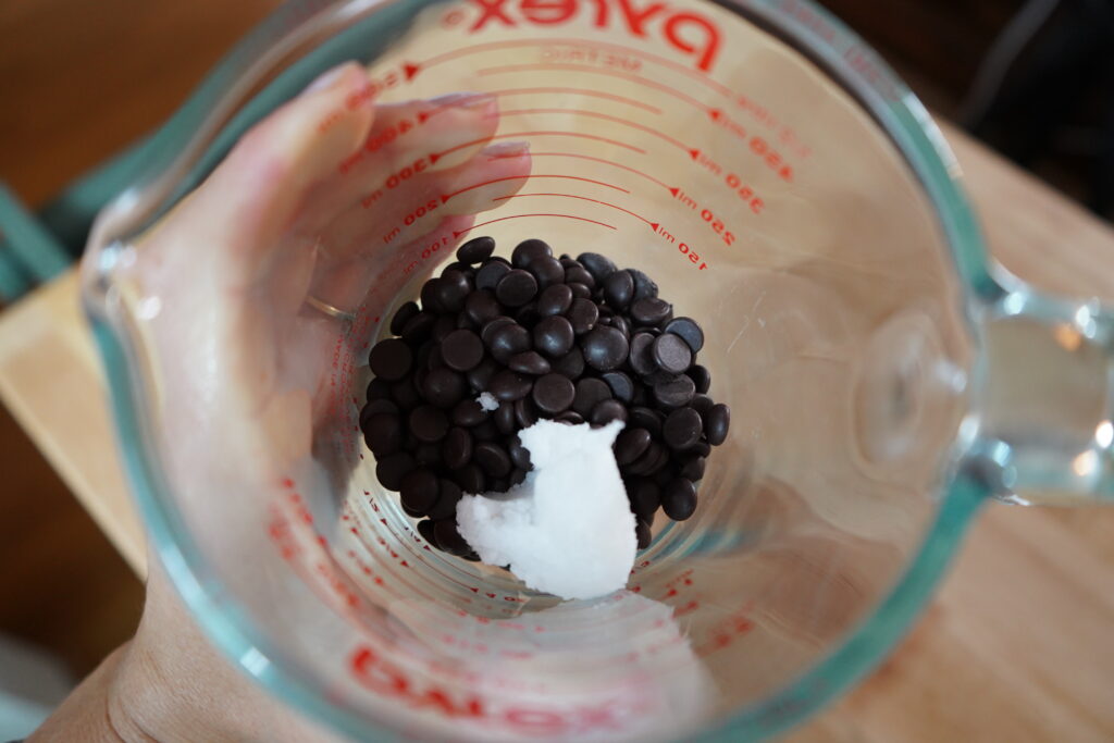 chocolate chips and coconut oil in a glass measuring cup