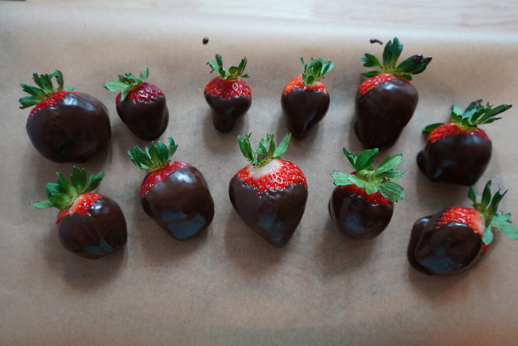 strawberries  on parchment paper covered in chocolate