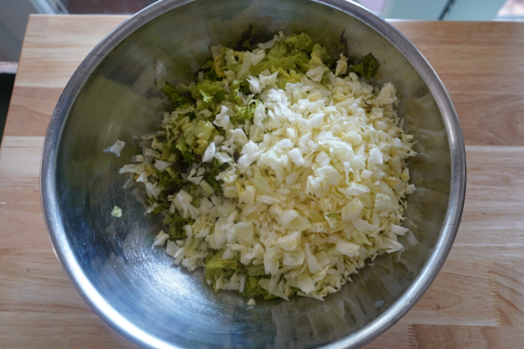 cabbage and romaine in a mixing bowl