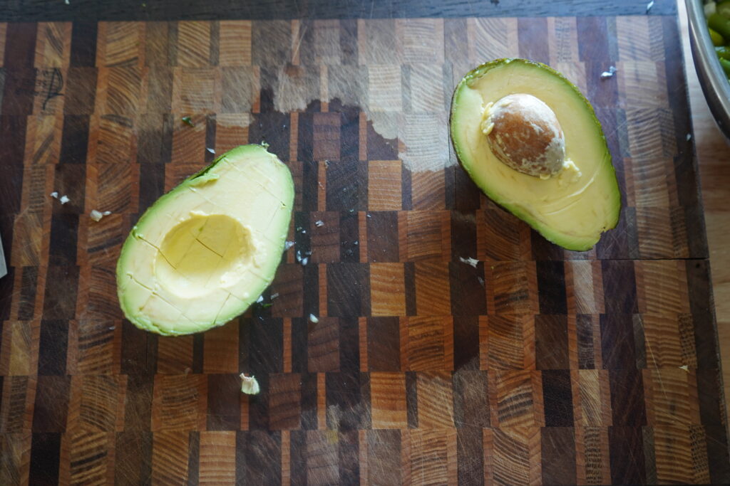 an avocado cut in half on a cutting board