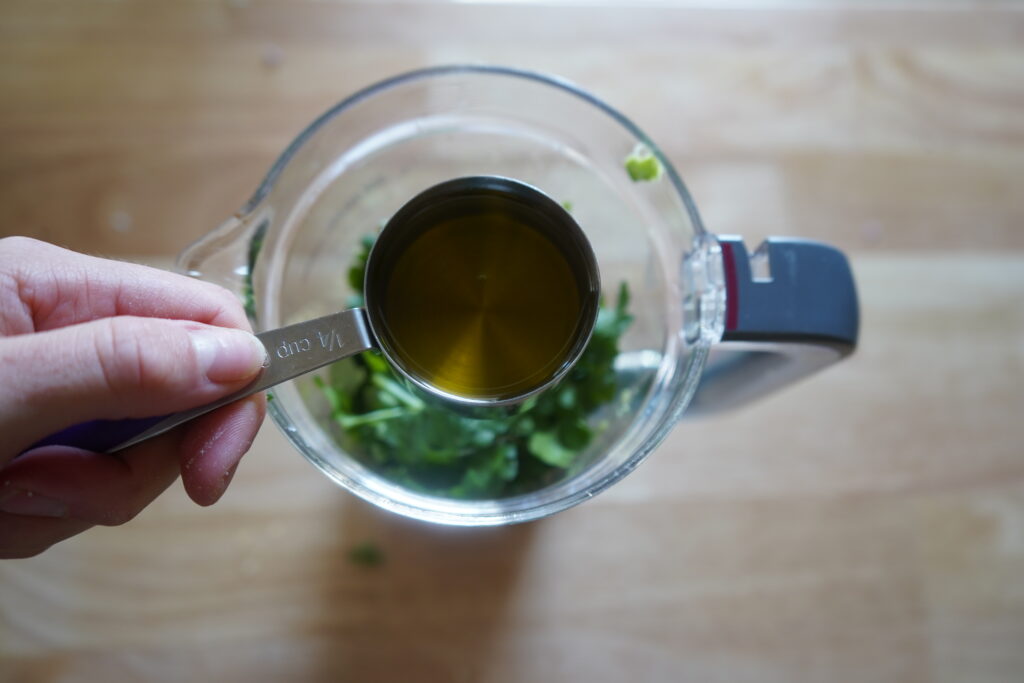 olive oil being added to a blender