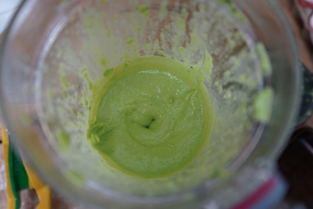 the inside of a blender with a green dressing inside