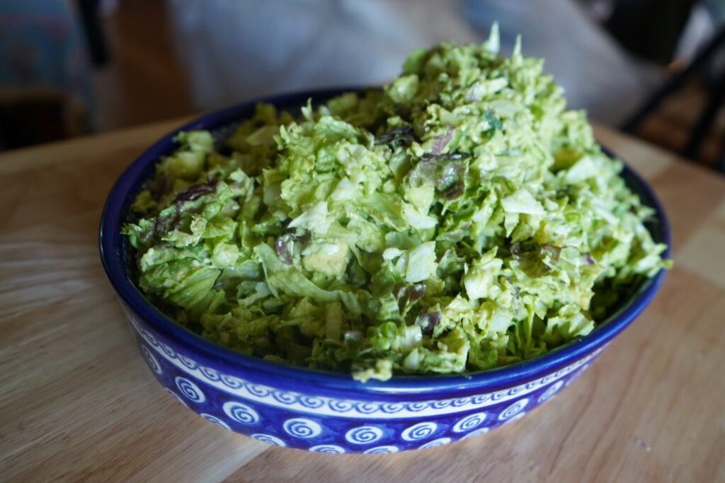 a blue serving bowl with a green goddess salad inside