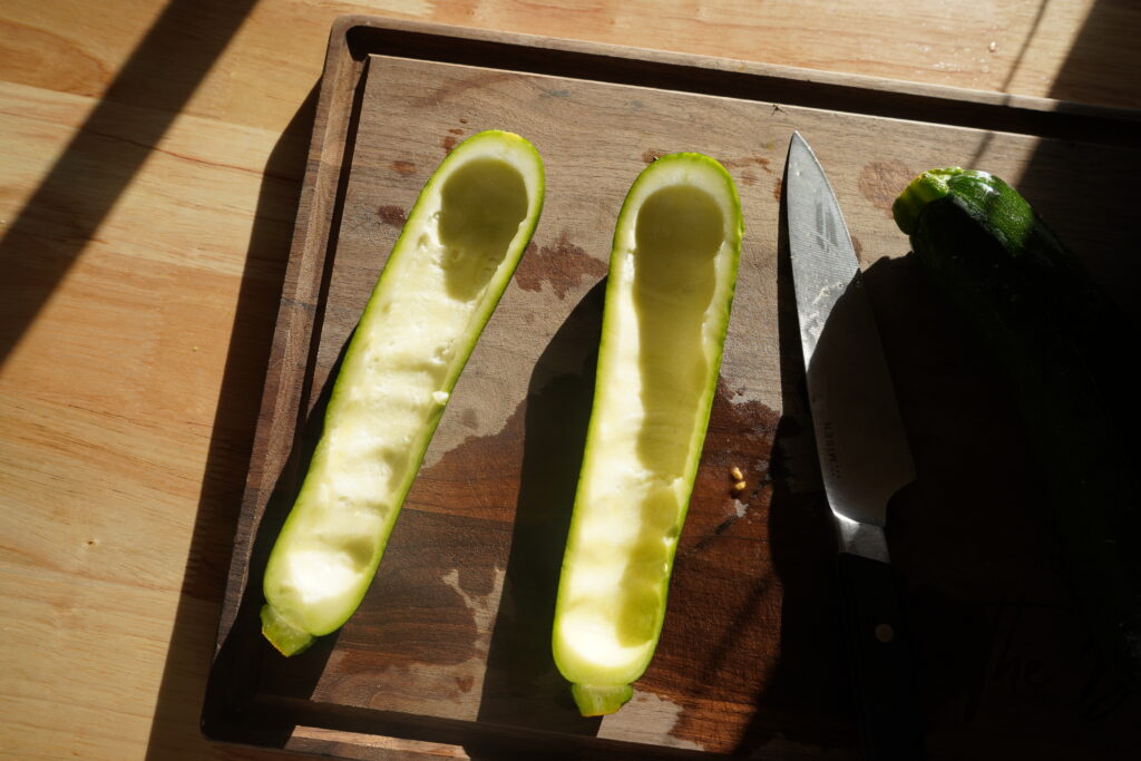 a zucchini on a cutting board that has been cored