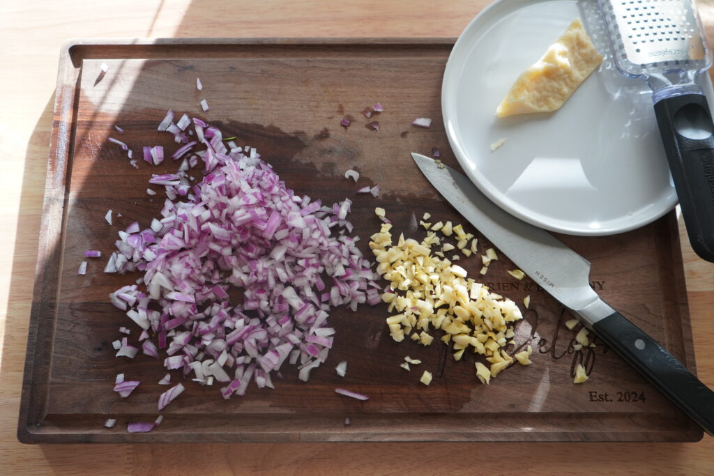 chopped onion and galric on a cutting board 