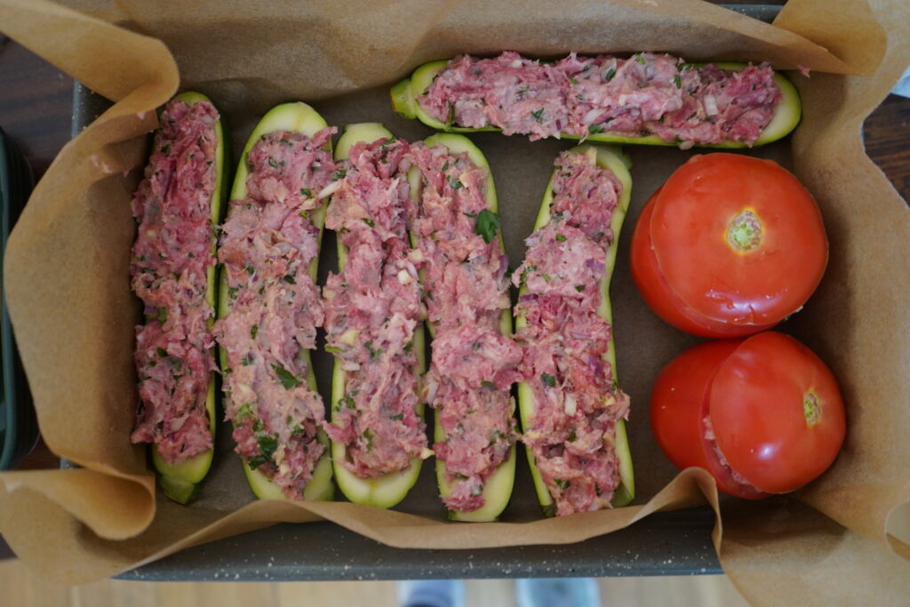 cored vegetables completely stuffed with ground meat in a baking dish