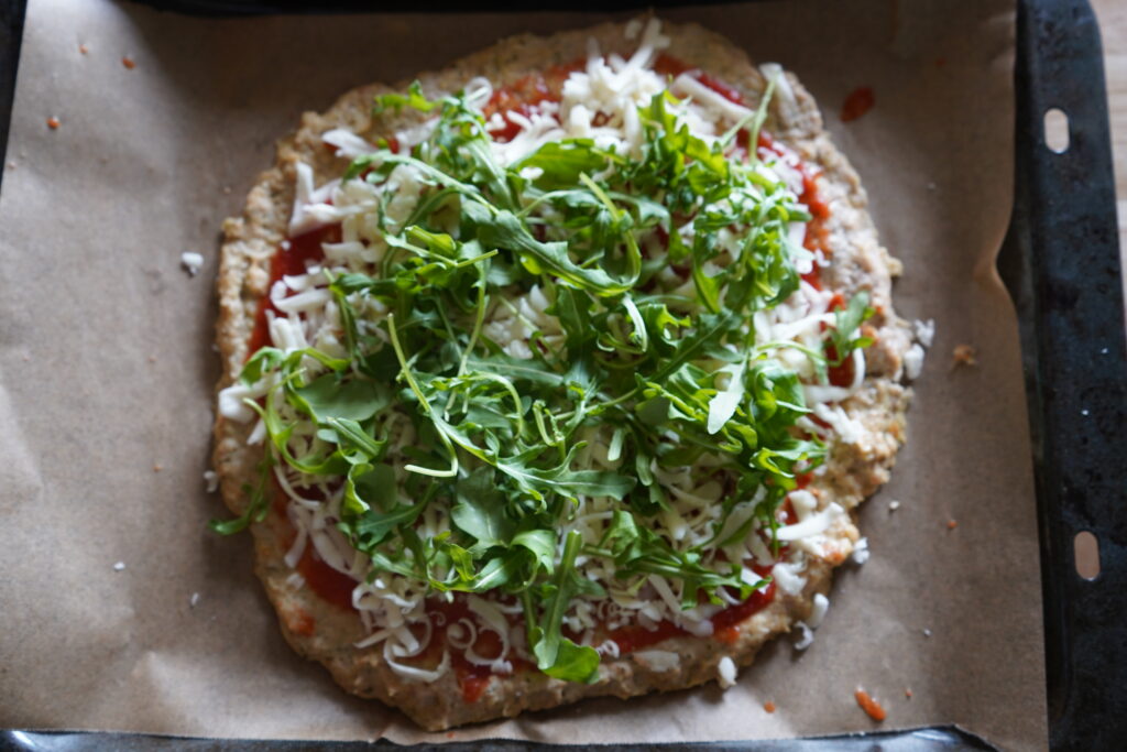 a pizza topped with arugula 