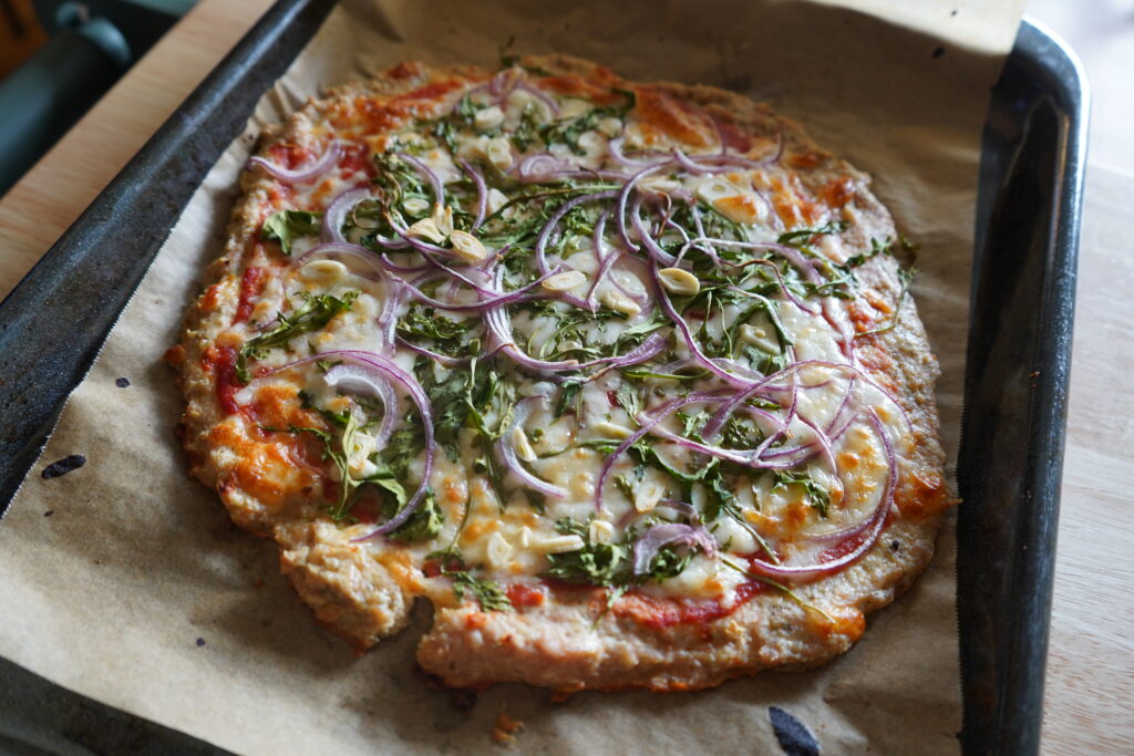 a chicken crusted pizza cooked on a baking tray