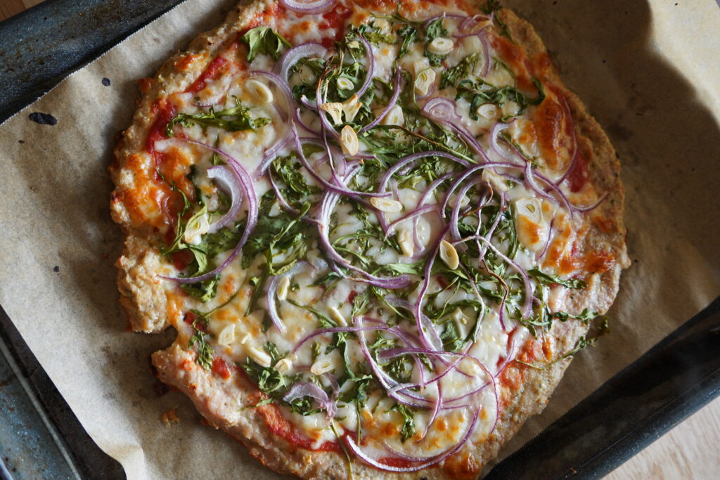 pizza chicken crust on a cooking sheet well cooked