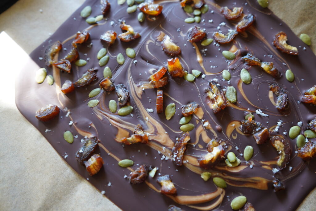 frozen chocolate bark topped with pumpkin seeds, dapes salt and peanut butter