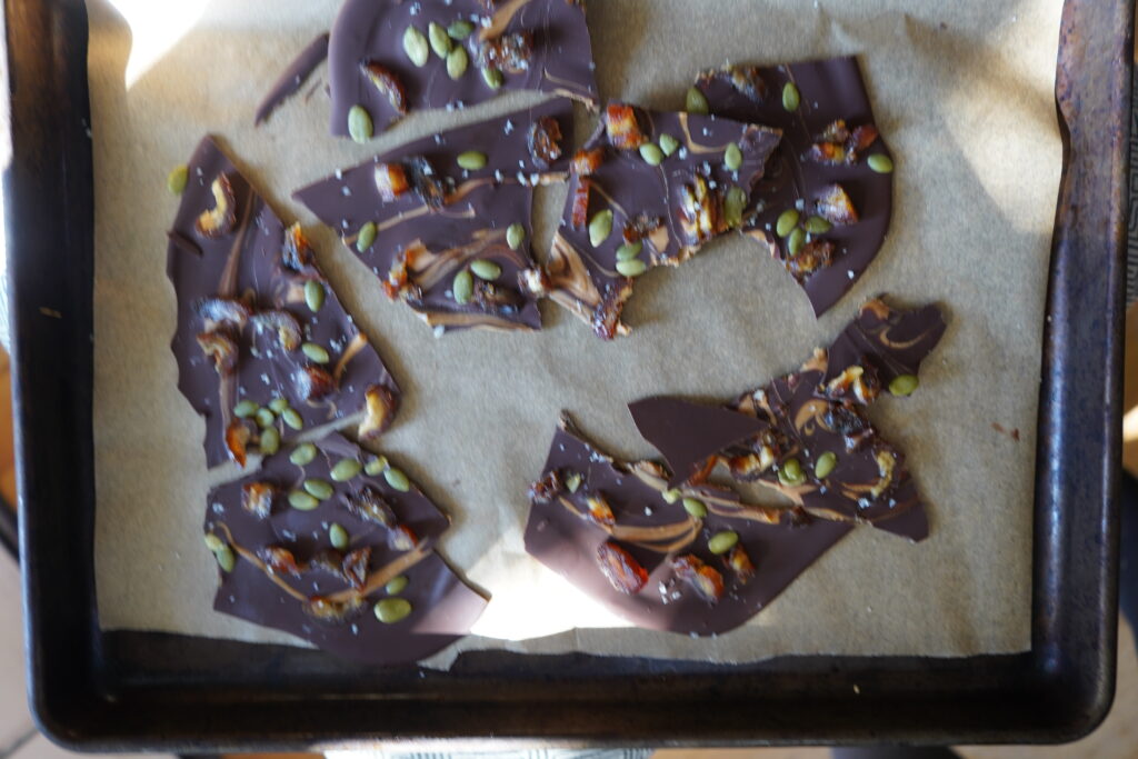 broken apart frozen healthy chocolate bark on a parchment lined pan
