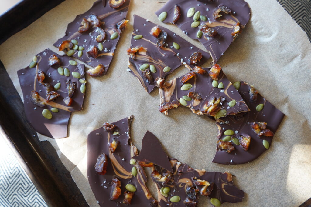 frozen, broken, healthy chocolate date bark on a pan lined with parchment paper