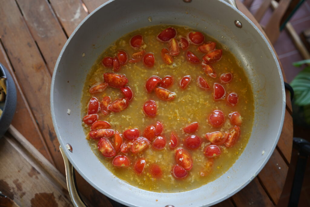 cherry tomatoes and broth in a pan