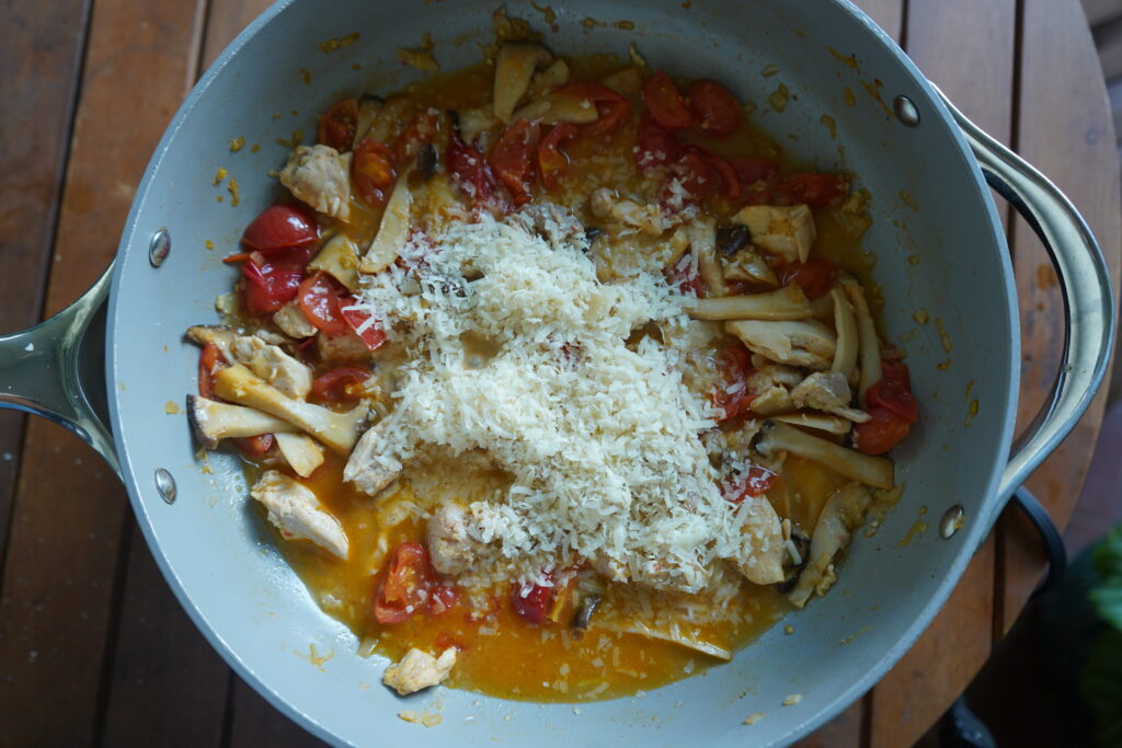 parmesan added to your pan of cherry tomatoes in sauce