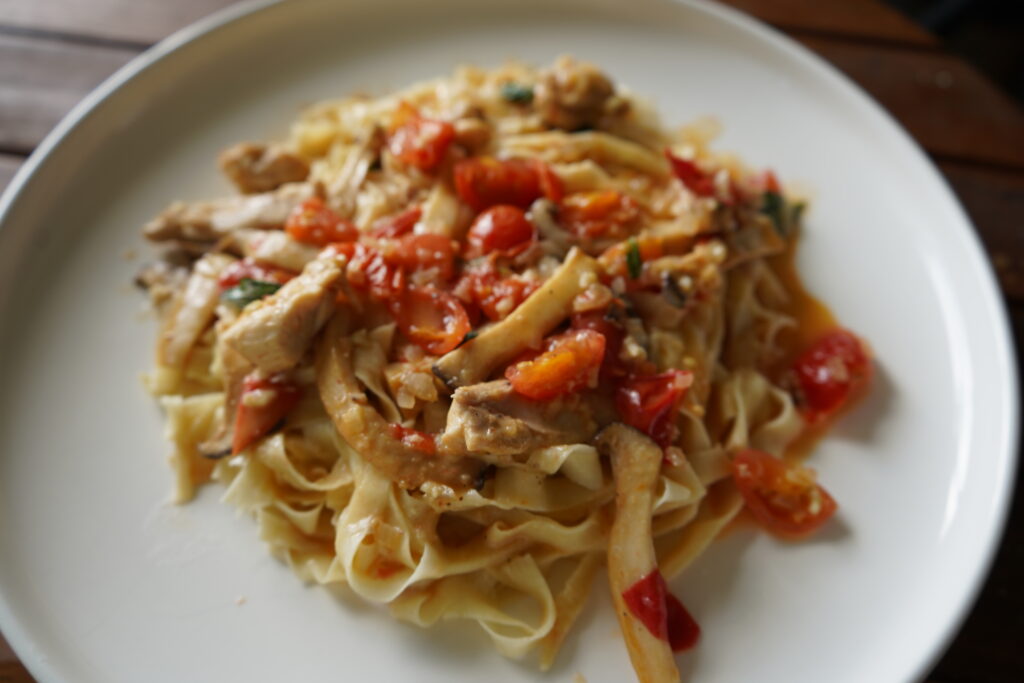 Pasta topped with an oyster, tomato, white wine sauce