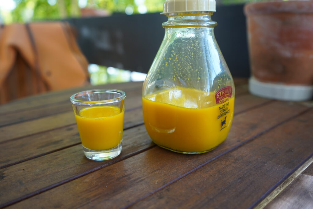 wellness drink in a shot glass on a wooden table
