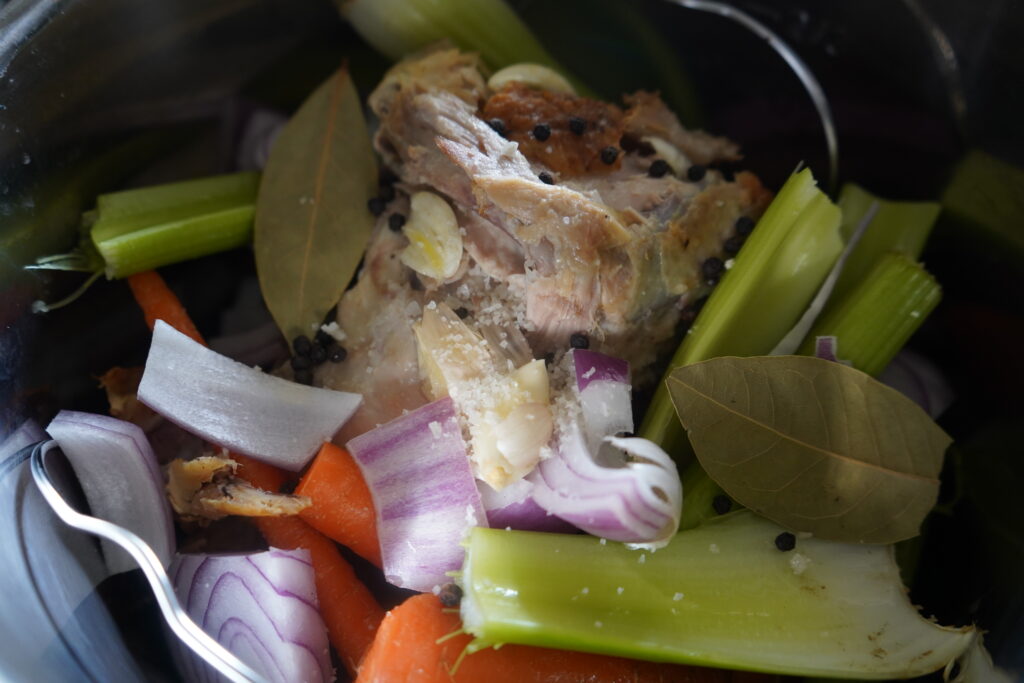 bay leaves and bones and vegetables in a pot