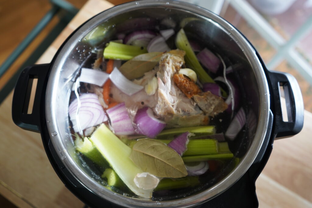water filled in an instant pot with vegetables in it