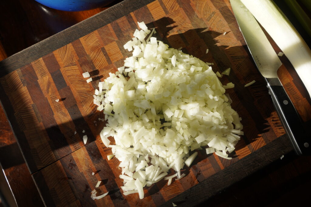 Chopped onion on a brown cutting board