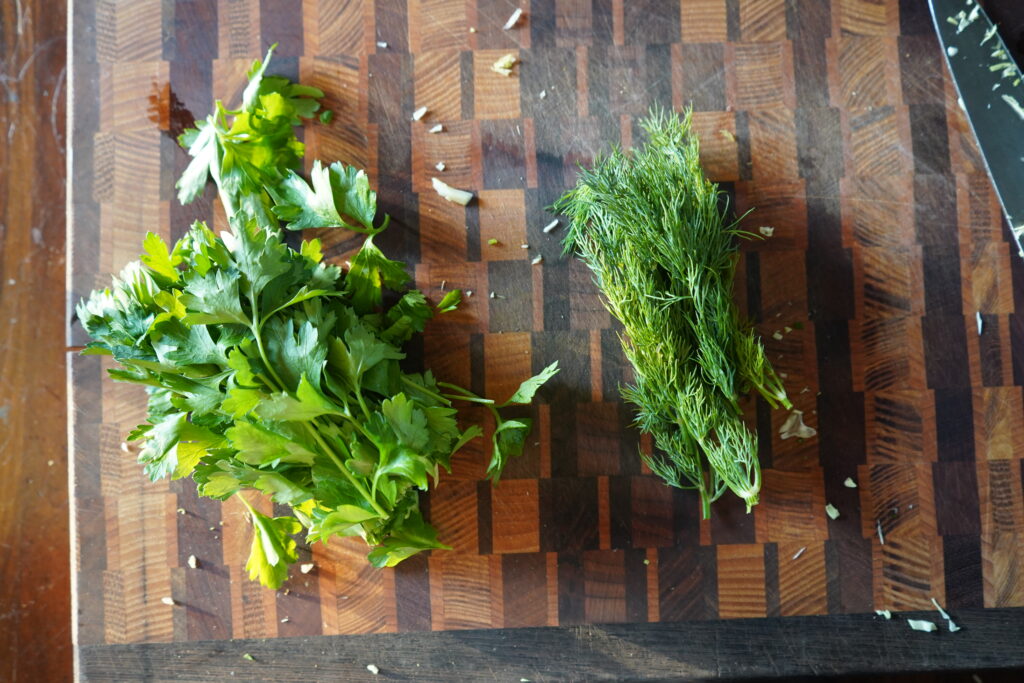 parsley and dill on a cutting board