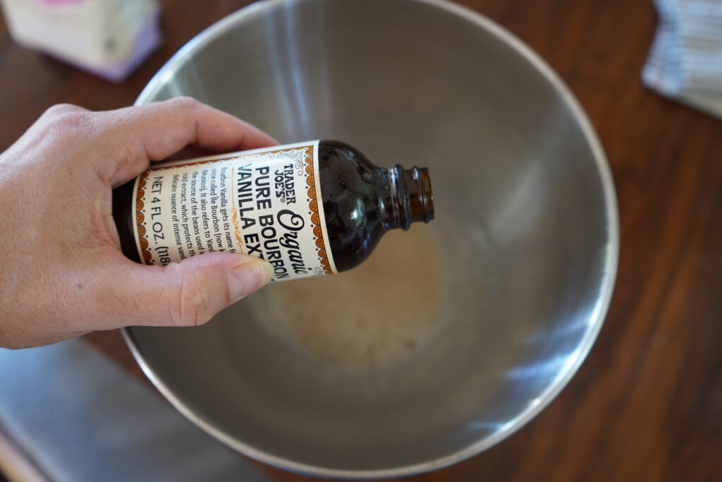vanilla extract being added to a mixing bowl