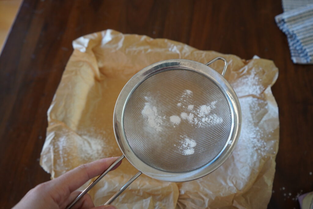 arrowroot powder on a fine strainer over the parchment lined dish