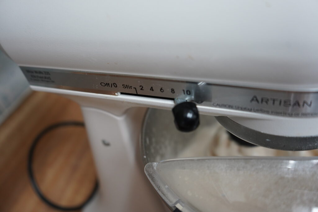 the speed on the side of a stand mixer being turned up to 10 speed