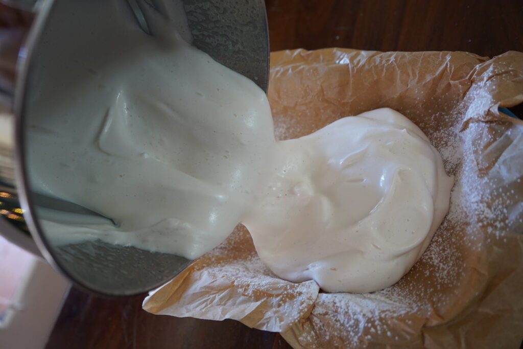fresh marshmallow being poured into a parchment lined dish
