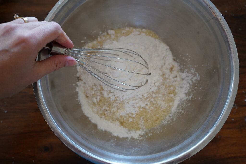 a whisk mixing dry ingredeints in a mixing bowl