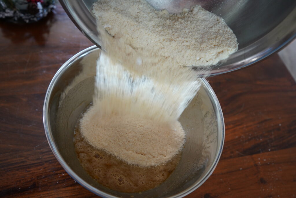 almond flour mix being poured into a wet ingredients mix for muffins