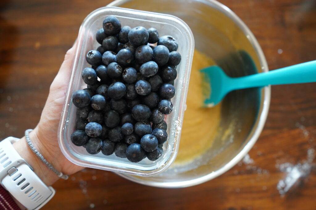 a bowl of blueberries over a mixing bowl