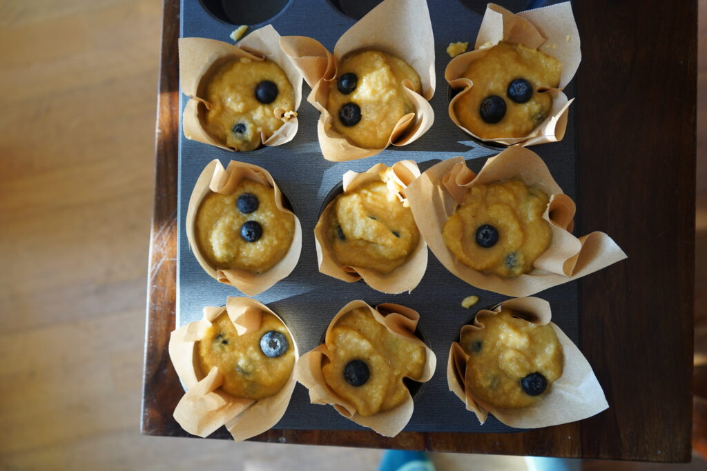 uncooked muffins with blueberries in them in a muffin tin