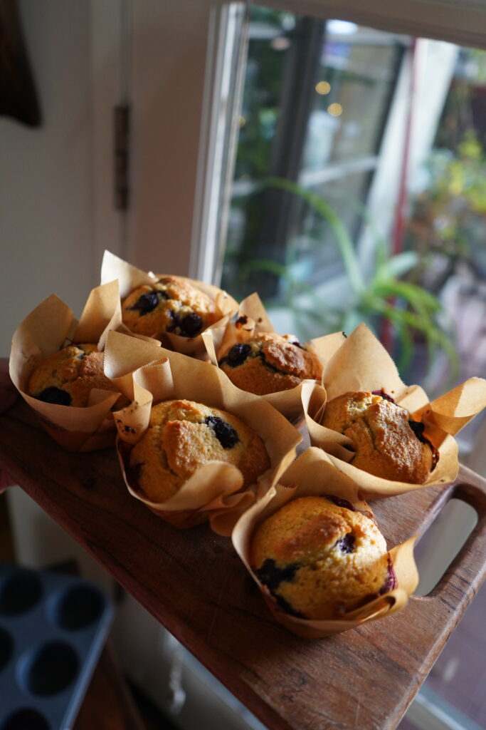 muffins with blueberries in them on a wodden cutting board